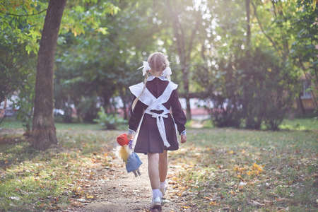 little girl with a doll in her hands leaves into the distanceの写真素材