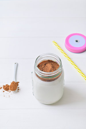 Morning healthy breakfast. Cocoa milk and oatmeal granules. Wooden white backgroundの写真素材