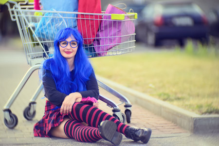 Woman sitting in a supermarket parking lot with bags. The concept of shopping and salesの写真素材