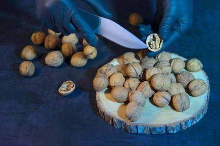 Chef peeling walnuts with a knife in the kitchen at the table.の写真素材
