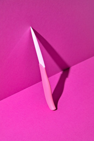 Ceramic pink knife. Magenta background. minimal style.の写真素材