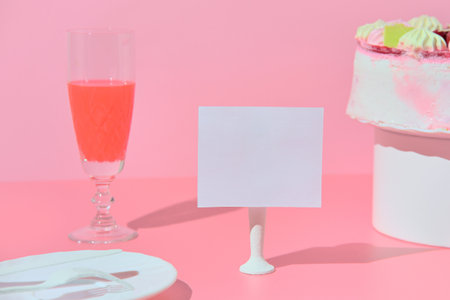 Mockup price tag on the table with a plate of wine glass and cake. pink background.の写真素材
