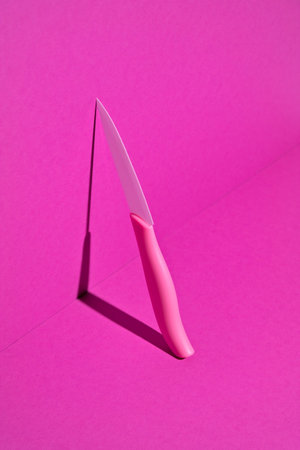 Ceramic pink knife. Magenta background. minimal style.の写真素材