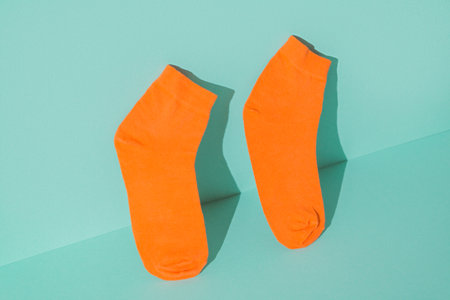 Orange socks new on the mint green background.の写真素材