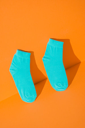 teal orange socks new on orange background.の写真素材