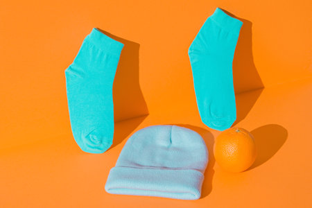 Layout new hat and socks, orange in the background. Mint green orange color.の写真素材