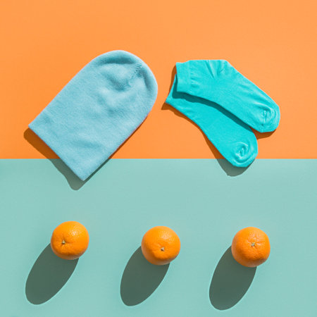 Layout new hat and socks, orange in the background. Teal orange color.の写真素材