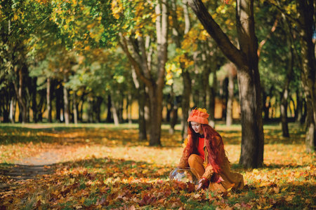 Redhaired girl in a hat collects autumn leaves in an aquarium. concept.の写真素材