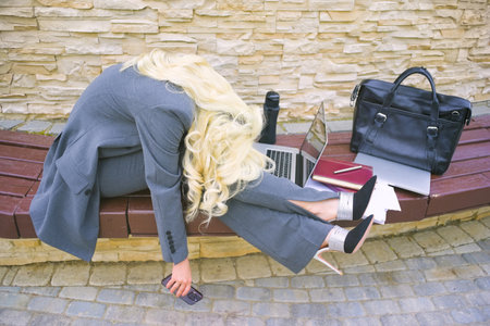 Businesswoman is tired. Woman lying on bench.の写真素材