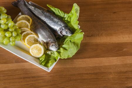Raw, whole trout, mediterranean themeの写真素材