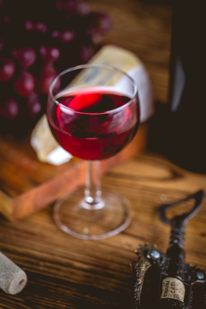 Glass of wine on wooden table, atmospheric compositionの写真素材
