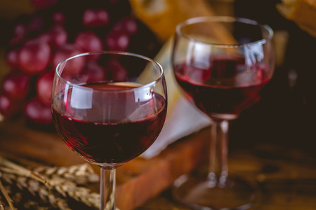 Glass of red wine on wooden tableの写真素材