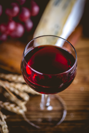 Glass of wine on wooden table, atmospheric compositionの写真素材