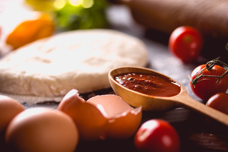 Fresh and tasty homemade pizza on wooden table with ingredientsの写真素材