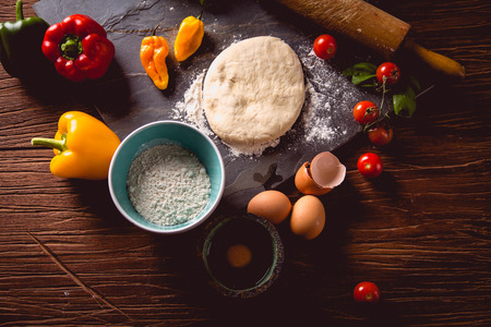 Fresh and tasty homemade pizza on wooden table with ingredientsの写真素材