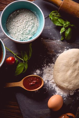 Dough with flour on wooden table, preparing homemade pizzaの写真素材