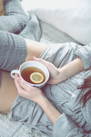 Cozy winter concept with girl drinking hot teaの写真素材