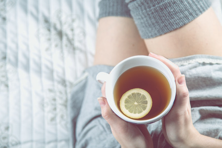 Cozy winter concept with girl drinking hot teaの写真素材