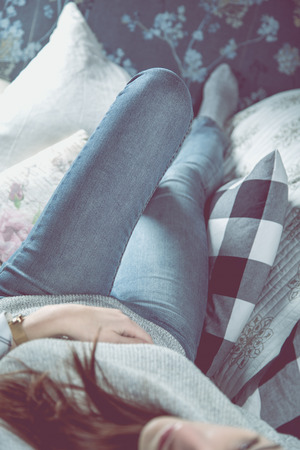 Beautiful girl is relaxing on the sofa, cozy conceptの写真素材