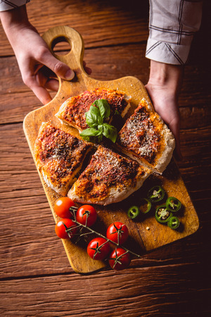Girl has fresh homemade pizza bread ready to eatの写真素材