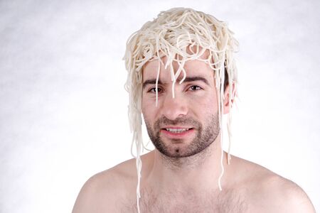 Funny man with spaghetti on head, white backgroundの写真素材