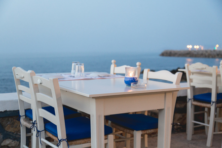 Ambient atmospheric evening on Greek coast, white tables in restaurantの写真素材