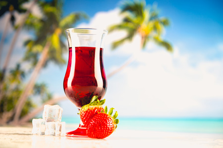 Cold tasty drink on a beach with palms in backgroundの写真素材