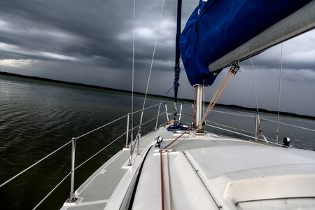 Sailing concept with boat and lake water storm weatherの写真素材