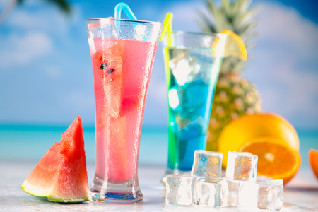Set of exotic drinks on the beach with blue ocean backgroundの写真素材
