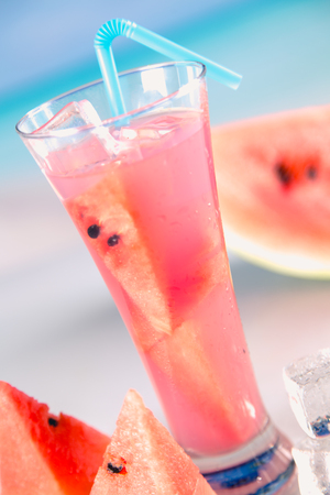 Watermelon ice cold drink on a beach with palmsの写真素材