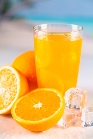 Fresh and cold orange juice served on beachの写真素材