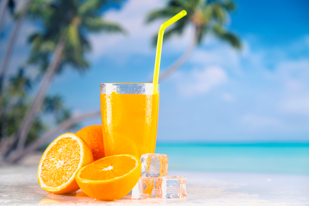 Fresh and cold orange juice served on beachの写真素材