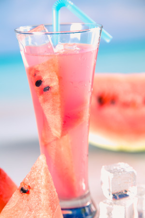 Watermelon ice cold drink on a beach with palmsの写真素材