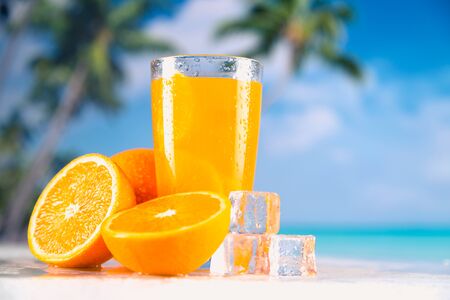 Fresh and cold orange juice served on beachの写真素材