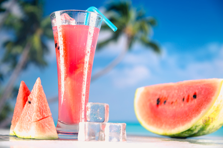 Watermelon ice cold drink on a beach with palmsの写真素材