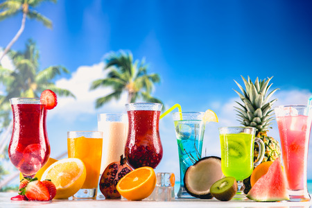 Set of exotic drinks on the beach with blue ocean backgroundの写真素材
