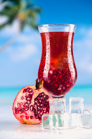 Cold tasty drink on a beach with palms in backgroundの写真素材