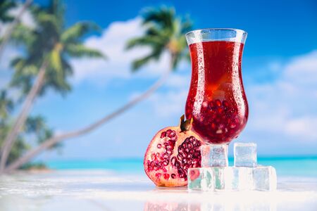 Cold tasty drink on a beach with palms in backgroundの写真素材