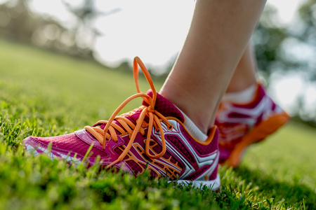 Legs of sportswomen on green grass training fieldの写真素材