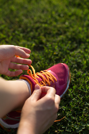 Legs of sportswomen on green grass training fieldの写真素材