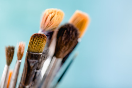Paint brushes on light blue background, close up shotの写真素材