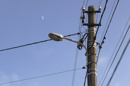electricity post with moon on blue sky background, Ukraine.の写真素材