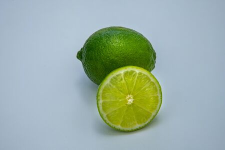 Lime slice and whole green lime isolated on white