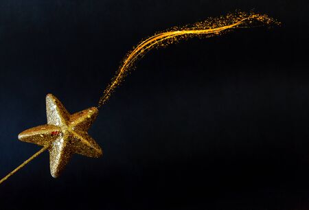 Golden star magiÑ wand isolated on black background
