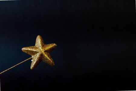 Golden star magiÑ wand isolated on black backgroundの写真素材