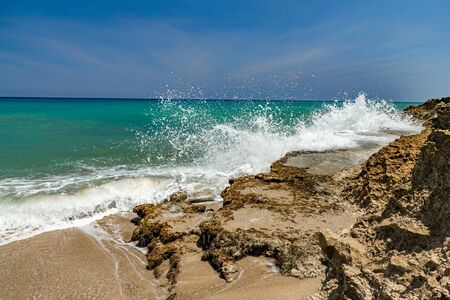 Ocean foamy waves, splashes at the beach near rocksの写真素材