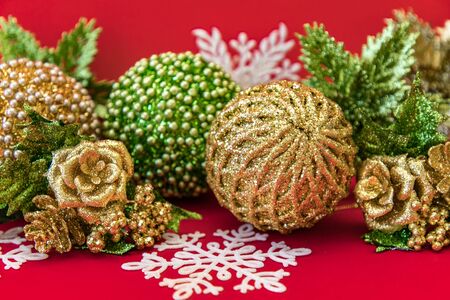 Golden, white and green Christmas decoration on red backgroundの写真素材