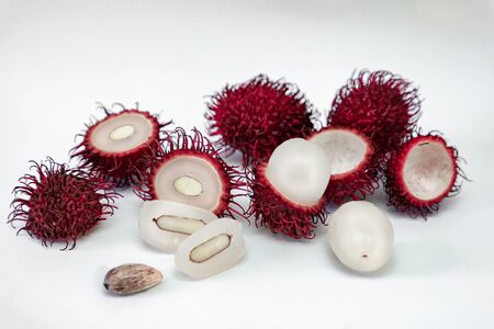 Hairy tropical exotic rambutan fruit, whole, half, cut, seed, flesh isolated on white background, template for border design with free space for textの写真素材