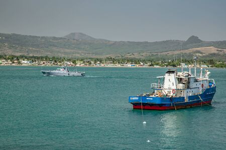 Ships, boats, containers, industrial buildings at the Puerto Plata harbor, port and cityscape, Dominican Republicの写真素材