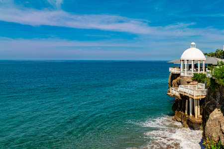 Sailing boat, ocean and coastline view from terrace with white balustradesの写真素材